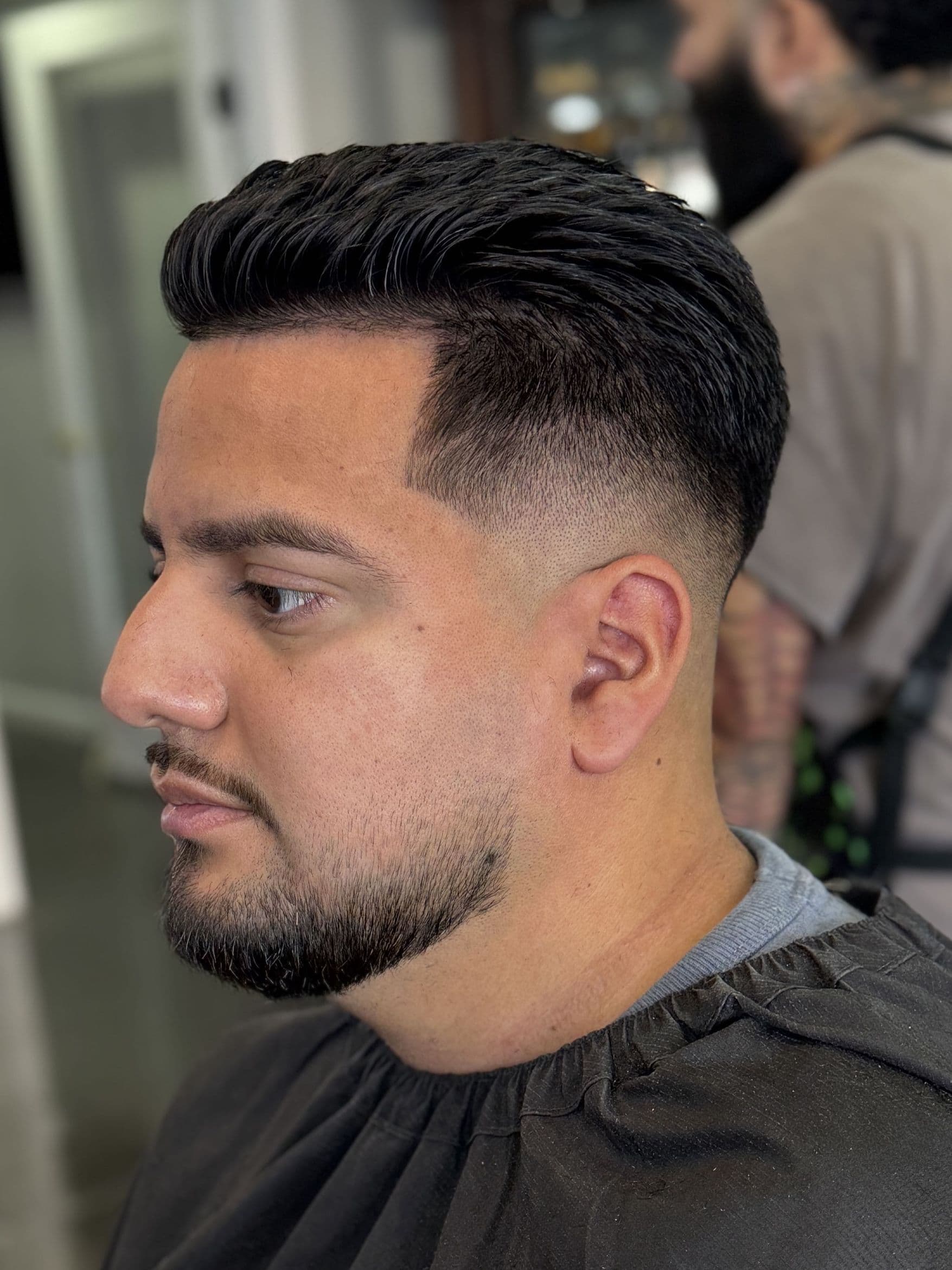 Slicked-back comb over with a mid skin fade and sharp line-up.