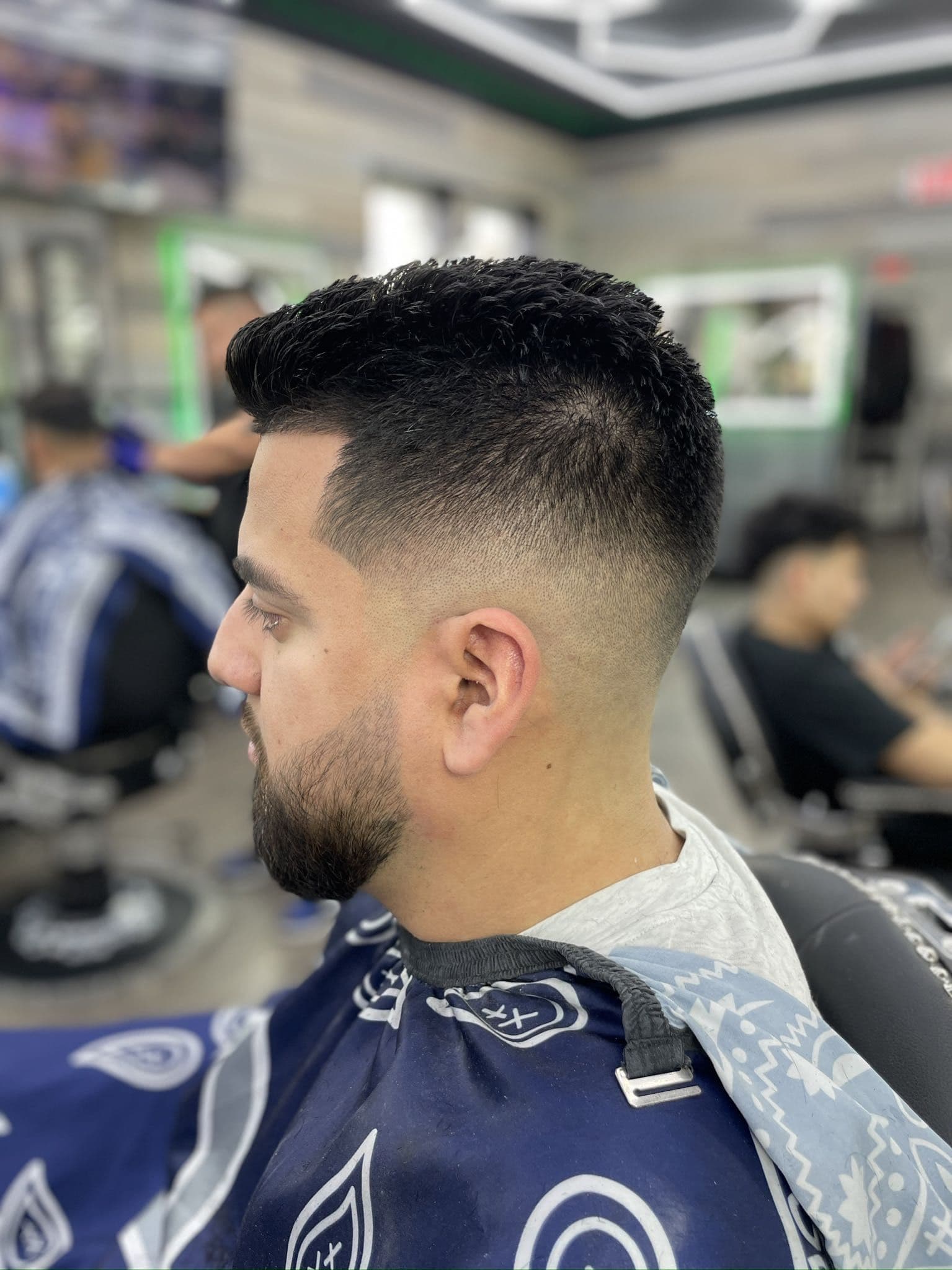 Textured crop with a mid fade, line-up, and tapered beard.