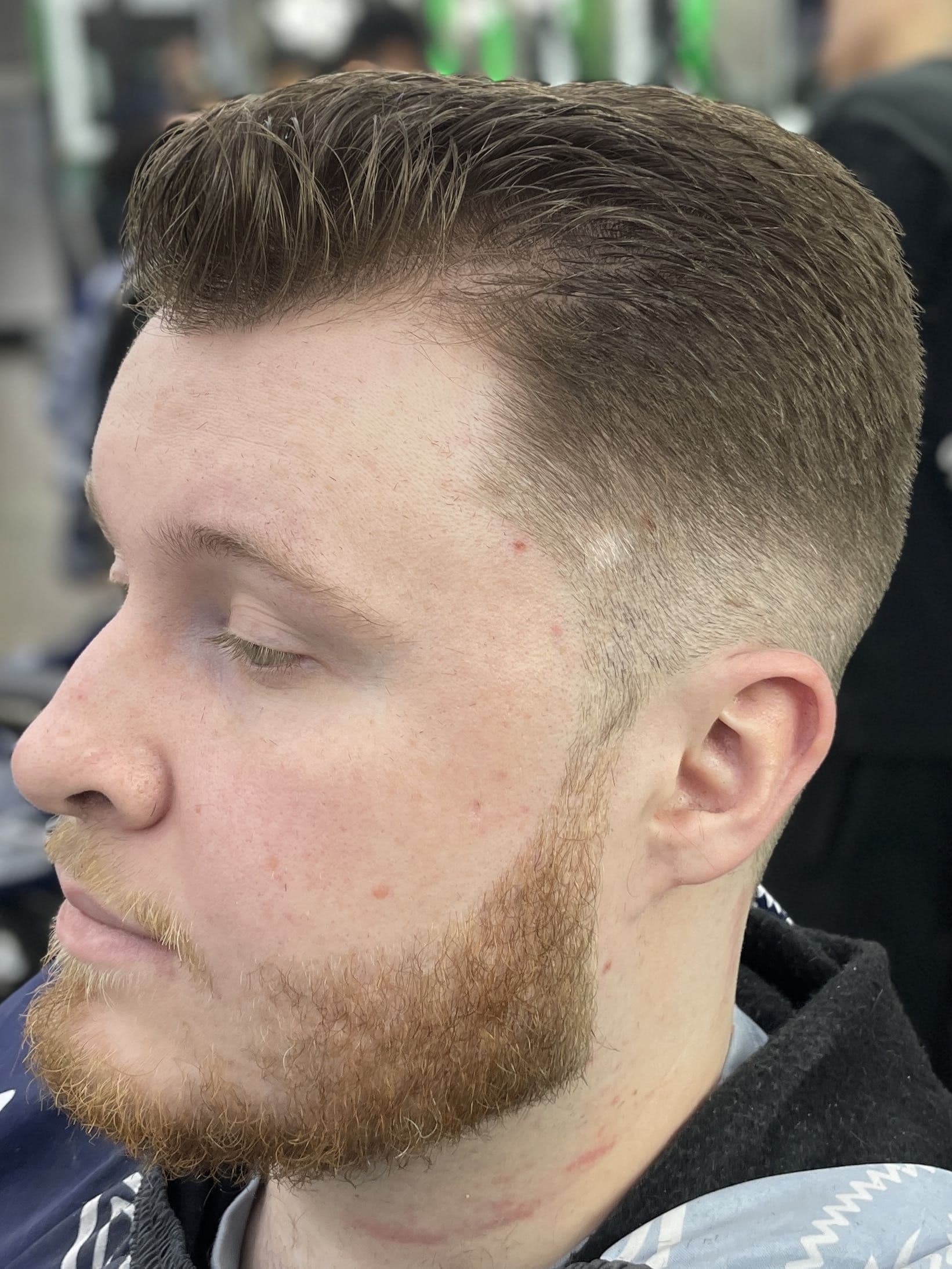 Low taper with scissor top, side sweep, and natural beard blend.