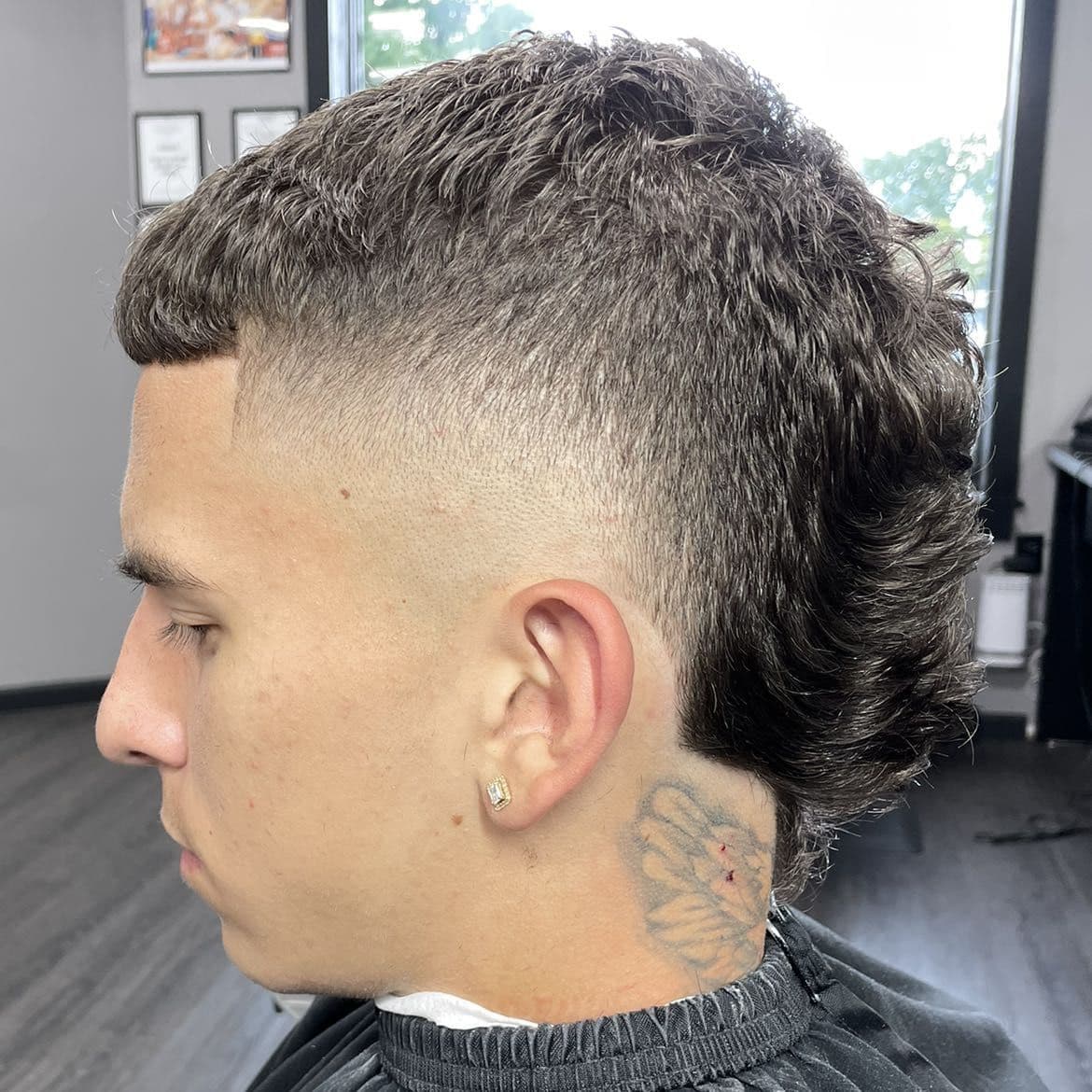 Curly mullet with a high skin fade and line-up.