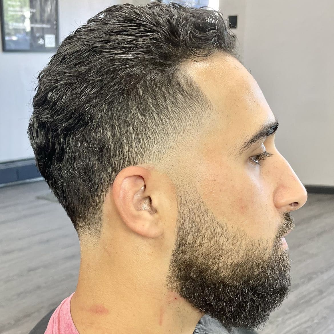 Short curly crop with a mid taper fade and beard shape-up.