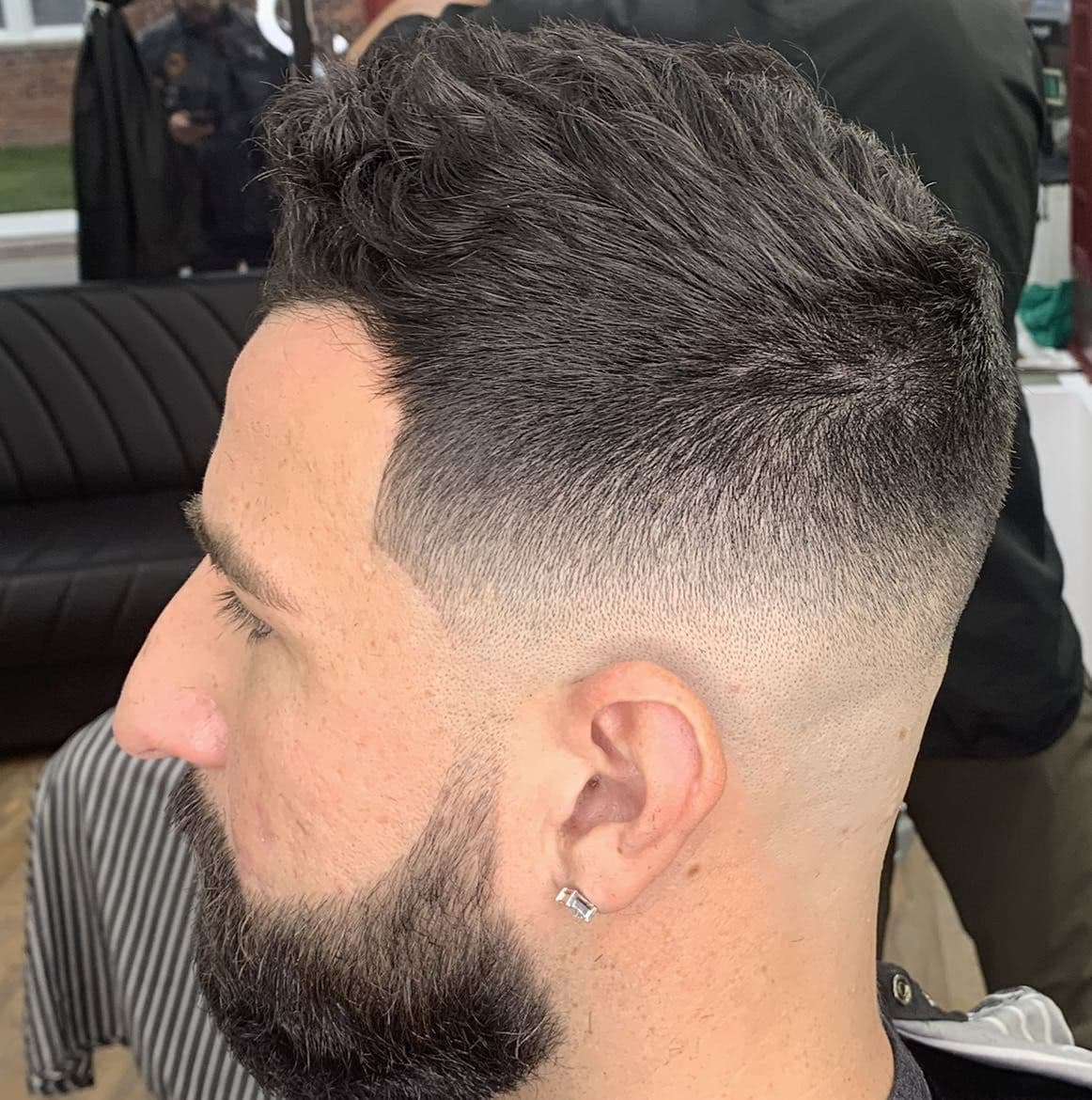 Textured brush-up with a mid skin fade and beard line-up.