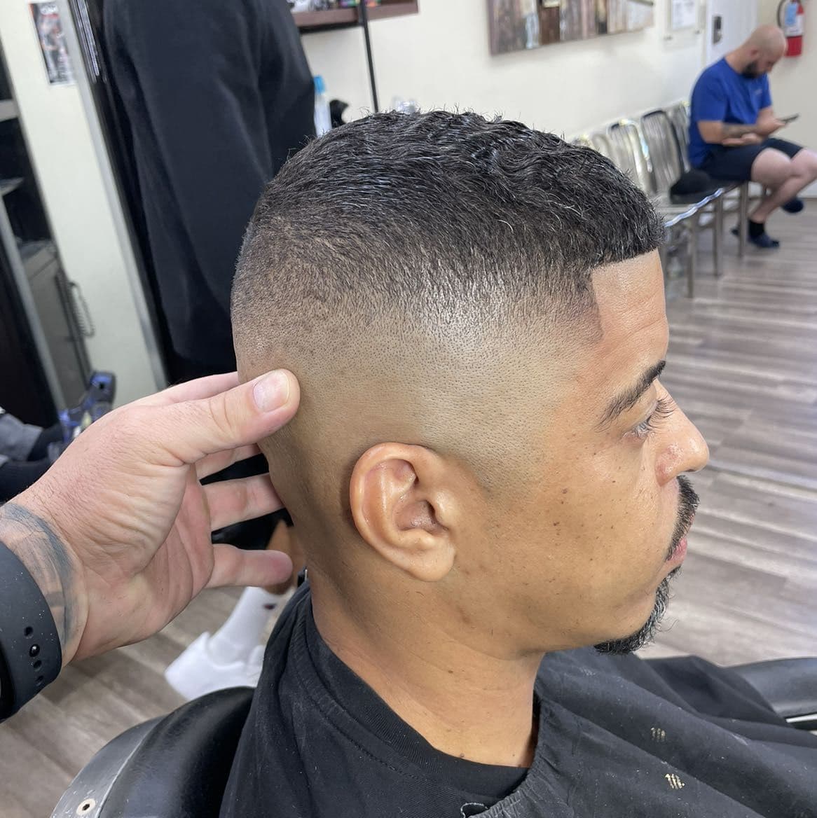 High skin fade with a buzz cut and line-up.